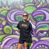 female model using not bad clothing Oversized TEE orange, sunglasses, purple and green graffiti
