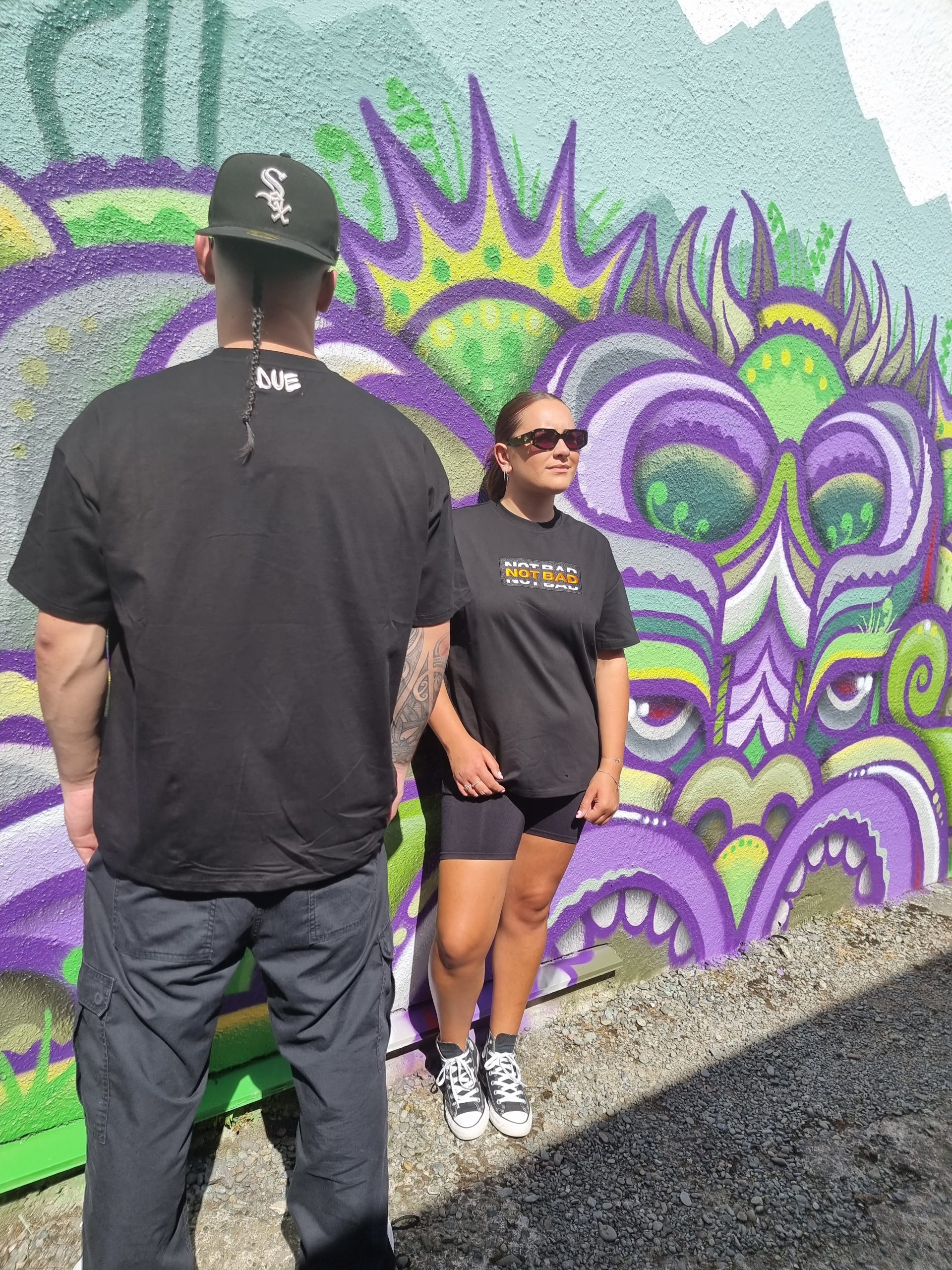 male model showing back and female model using not bad clothing oversized tee orange