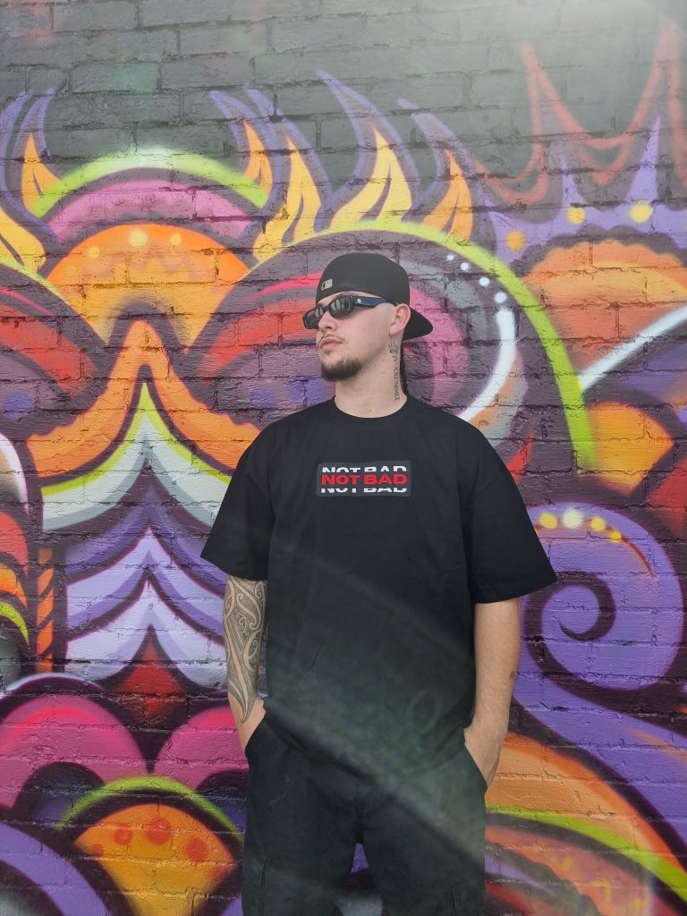 male model using not bad clothing Oversized TEE red, colour graffiti wall